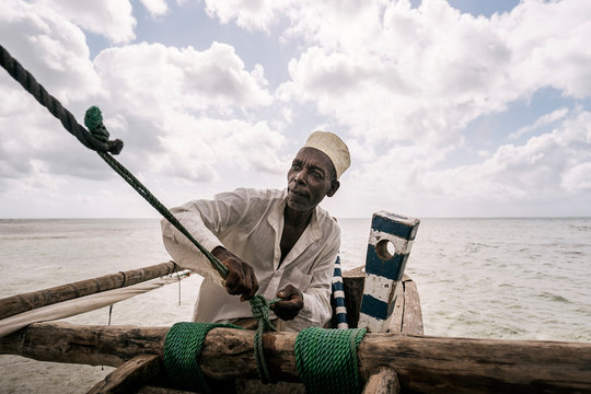 Zanzibari fisherman pulling rope, keeping balance to navigate hi