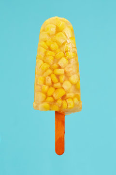 Popsicle made of sweetcorn against blue background