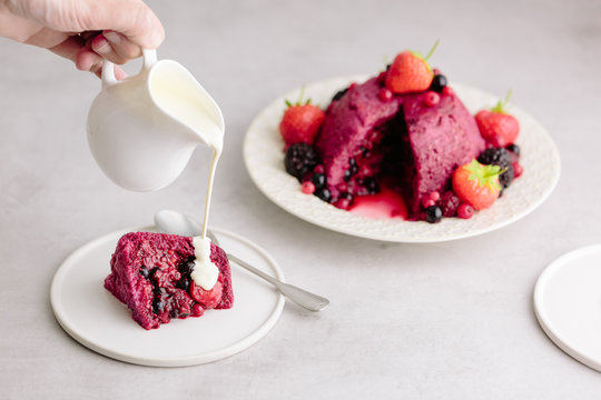 Pouring cream onto Summer Pudding, classic English dessert