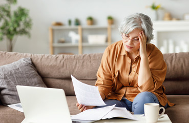 Stressed senior freelancer reading document