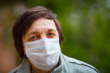an adult woman, a pensioner, on a walk in a medical mask