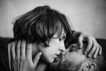 young woman kissing her beloved wrinkled man