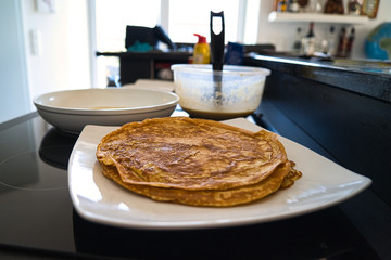 Dessert Nachspeise frischer Vollkorn Crepe Pfannkuchen beim braten in einer weißen Pfanne mit...