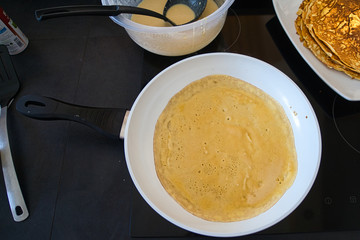 Dessert Nachspeise Crepe Pfannkuchen beim braten in einer weißen Pfanne mit Rührschüssel