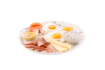 Three fried eggs garnished with cheese, ham and tomatoes. Photo taken on a white background. Dish of Montenegrin cuisine. Suitable for the restaurant menu.