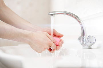 a personal hygiene rules, person with a soap brick piece and wash his dirty hands, coronavirus covid protection