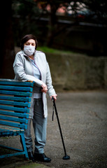 an adult woman, a pensioner, on a walk in a medical mask