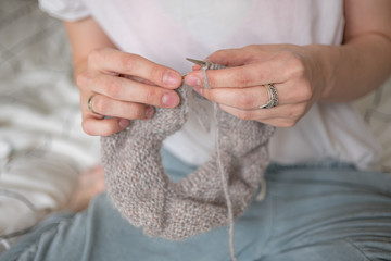 Hands knitting sweeter with needles close up. DIY, craft, handmade, artisanal 