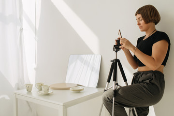 Woman take photos with porcelain via smartphone
