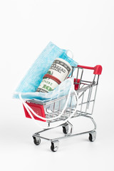 Sale of medical masks. Medical mask in shop trolley with money on white background. Coronavirus concept. 2019 nCoV.