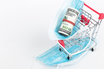 Sale of medical masks. Medical mask in shop trolley with money on white background. Coronavirus concept. 2019 nCoV.