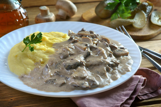 beef Stroganoff with mashed potatoes on a wooden background