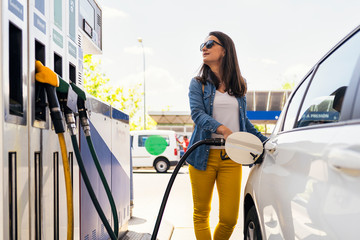 Beautiful woman filling the car's tank