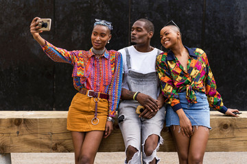 Group of african american friends using mobile phone outdoor
