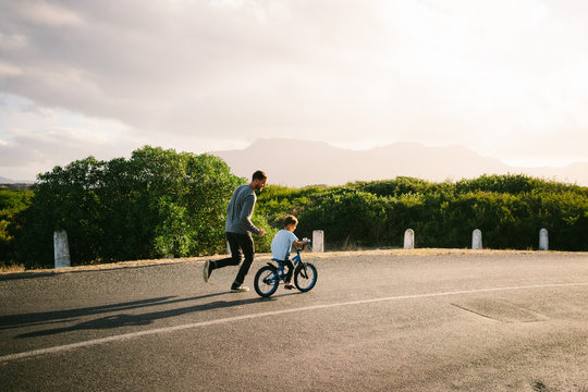 Dad teaching son to ride a bike