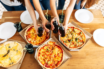 Appetizing pizza on the table and hands above it