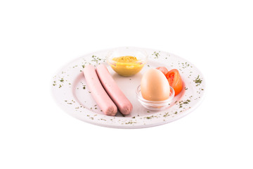 Boiled sausages with boiled egg, with tomatoes and mustard. Served on a white plate. Photo taken on a white background. Dish of Montenegrin cuisine. Suitable for the restaurant menu.