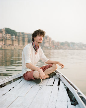 Western man on a boat exploring the River Ganges
