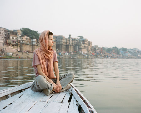 Western woman on a boat exploring the River Ganges