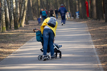 Mom with stroller for a walk in the park. People