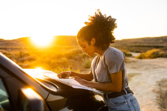 Traveler woman looking for direction on a map in Bardenas, Navarra