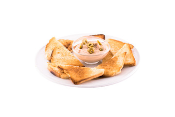 Heated bread (toast) with cream sauce and green olives. Served on a white plate. Photo taken on a white background. Dish of Montenegrin cuisine. Suitable for the restaurant menu.