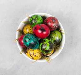 Easter colored quail eggs in a bowl top view