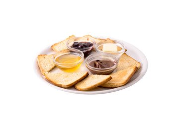 Heated bread (toast) with honey, jam, butter and chocolate. Served on a white plate. Photo taken on a white background. Dish of Montenegrin cuisine. Suitable for the restaurant menu.