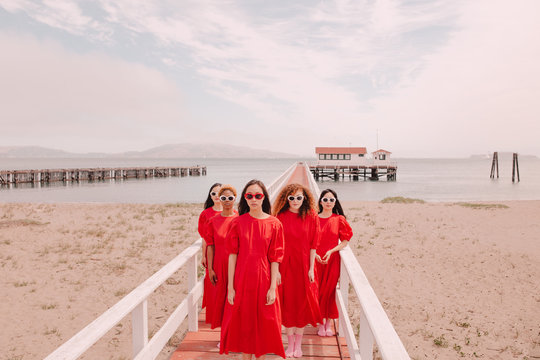 Portrait of women in red dress standing on pier