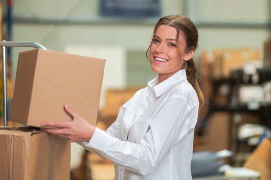 Frau lacht und arbeitet im Lager