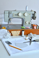 Homemade medical mask in the process. Sewing virus face mask at home. Detail on sewing machine.Letter CORONAVIRUS STOP