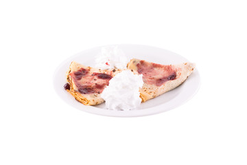 Pancakes with fruit jam, butter cream and nuts. Served on a white plate, melted on a white background. The photo is suitable for feeding mei restaurant. Dish of Montenegrin cuisine.