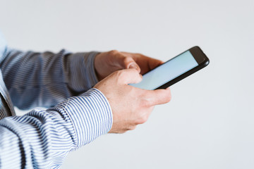 close up view of a man using mobile phone indoors. Technology concept