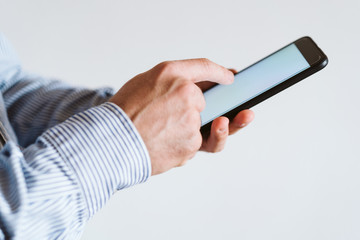 close up view of a man using mobile phone indoors. Technology concept
