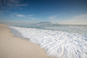 Wide angle view of Table Mountain, one of the natural seven wonders of the world, as seen from Blouberg Beach in Cape Town South Africa
