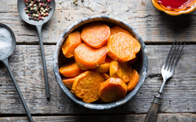 Delicious fried sweet potatoes on the wooden background.