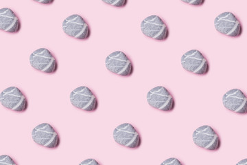 Sea pebble pattern on millennial pink pastel color flat lay background