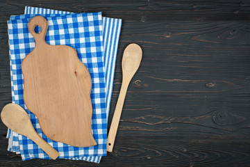 Blue checkered tablecloth and wooden appliances for cooking and baking. Background with copy space. Horizontal.