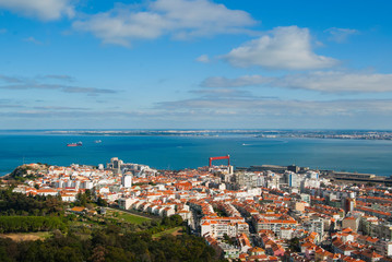 Fototapeta na wymiar Portugal's coastline, top view on the city on a sunny day. Houses with orange roofs and sea on the horizon. 