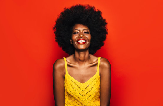 Happy Afro Woman posing over yellow background