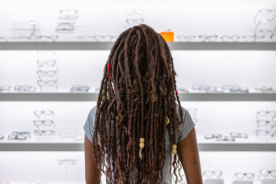 Eyewear: Woman With Dreadlocks Looks At Glasses