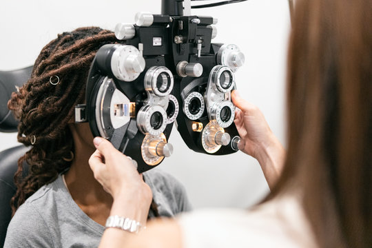 Eyewear: Woman Looks Through Phoropter To Measure Prescription