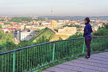 Fototapeta na wymiar Girl looking at Gediminas Tower and Lower Castle of Vilnius