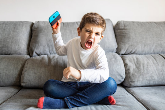 Excited Boy Playing Video Games At Home