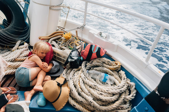 Little girl laying on the boat de?k floating in the sea