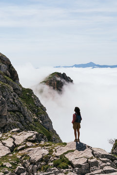Back view of a woman dazzled by majestic view of the summit at Picos de Europa