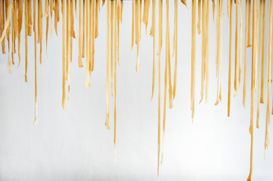 Fresh pasta dough hanging to dry