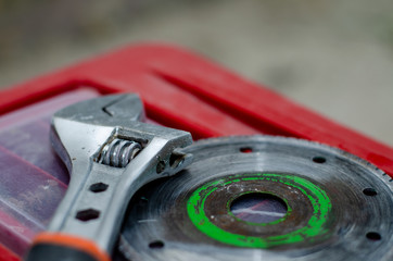 The circle for the grinder and the adjustable wrench are on the red tool box. Worker preparing for repair in the apartment.