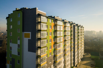 Aerial view of a tall residential apartment building with many windows and balconies.