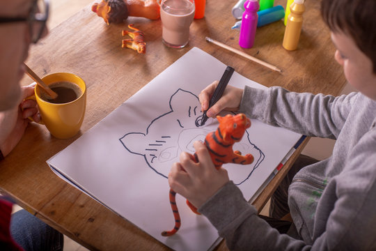 Boy drawing with his father